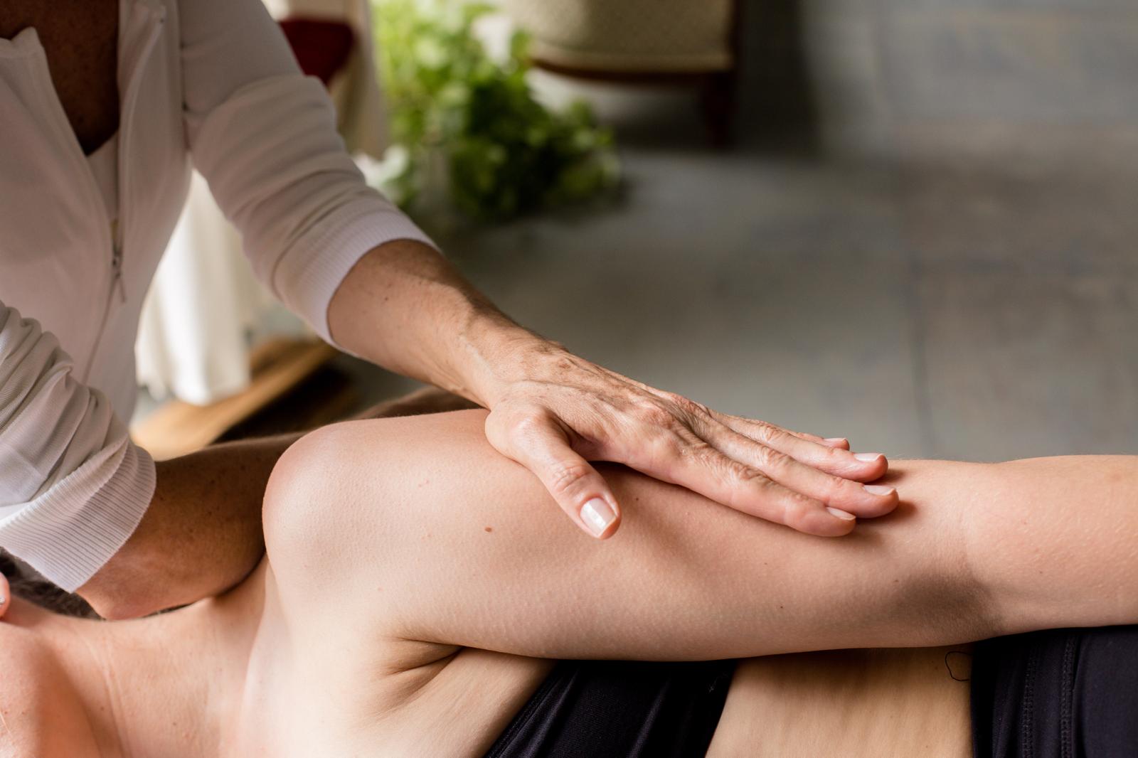Joyce&rsquo;s hands working a client&rsquo;s leg during a session.